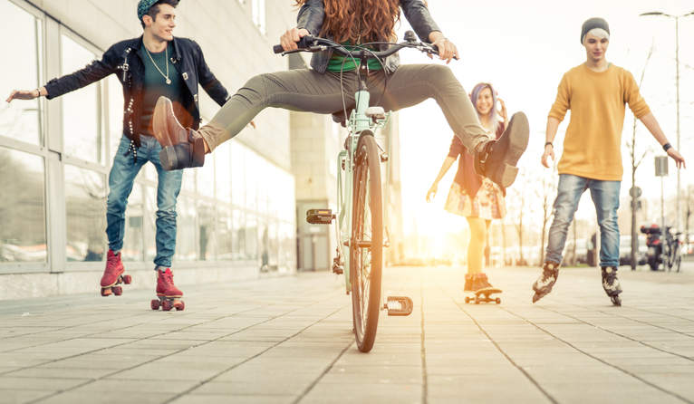 נוער מסתובב בעיר על רולרבליידס ואופניים